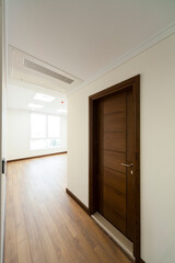 Wooden door inside the room with parquet and wallpaper and window light