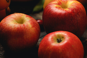 Pile of red apples on wooden table close up