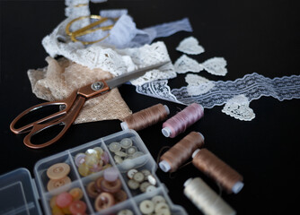 a stack of fabrics and sewing accessories on a tailor's table