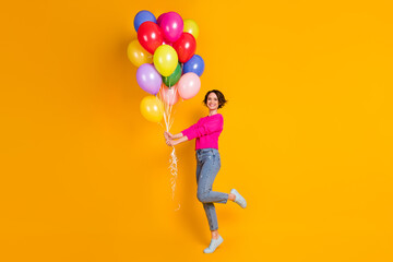 Full size photo of candid girl hold many balloons wear pullover isolated over vibrant color...
