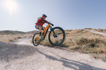 Fototapeta na wymiar cyclist jumping on trail with electric bike