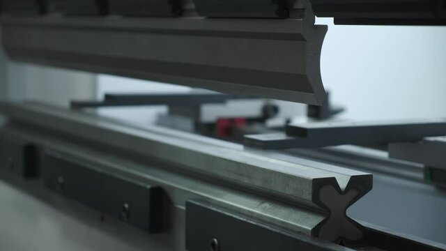 Automatic bending of a metal profile at metalware factory, close-up.