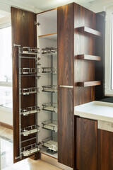 Modern kitchen, opened wooden drawers with accessories inside, solution for kitchen storage, minimalist interior design