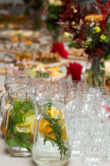 Festive buffet with a variety of delicious dishes, drinks and colorful bouquets.