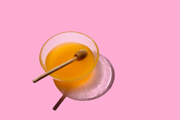 honey in a glass jar with hard light and shadows on a pink background is isolated. place for text . the concept of creative shooting hard shadows solid background