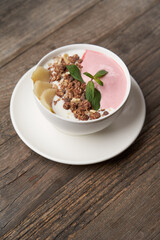 Granola with yogurt in white bowl. Healthy breakfast granola