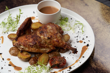 Grilled chicken Tabaka with baked potatoes and with sauce