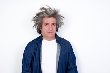 Handsome middle aged Caucasian man with afro gray hair, crying desperate and depressed with tears on his eyes suffering pain and depression. Sad facial expression and emotion concept.