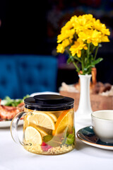 Fruit tea and flowers on a table.