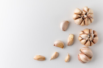 A lot of Garlic cloves and pieces of raw garlic on isolated white background. Top view Garlic bulbs with blank space.