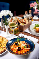 Pasta with seafood and a glass of white wine.