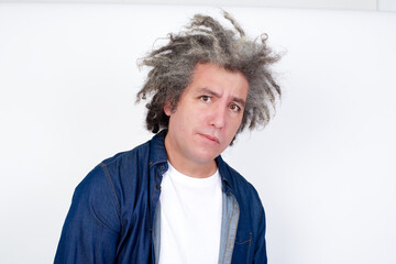 Handsome middle aged Caucasian man with afro gray hair, against  with snobbish expression curving lips and raising eyebrows, looking with doubtful and skeptical expression, suspect and doubt.