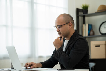 A middle-aged man around the age of 35. Working at home Work through the laptop by meeting video...