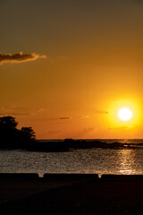 Fototapeta na wymiar 沈む太陽と小島と水平線