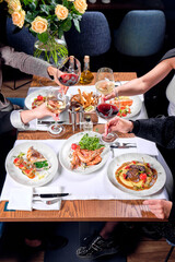 People at the table are holding glasses of wine.