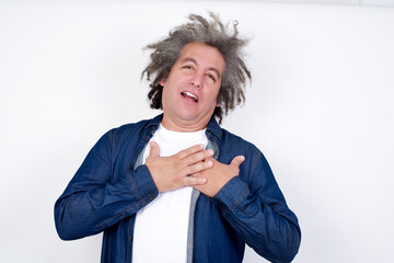 Happy smiling Handsome middle aged Caucasian man with afro gray hair, against white wall,  has...
