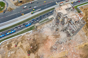 Aerial view of construction site with destroyed industrial building and excavators and traffic jam