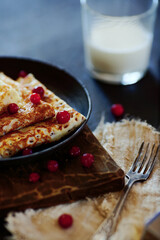 National Russian food. Pancakes in a frying pan with milk. Rustic stylization