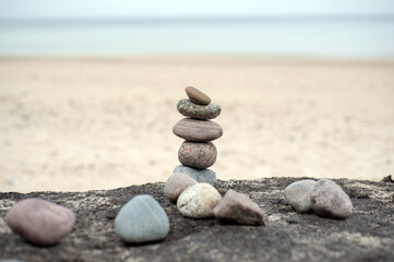 Fototapeta na wymiar Feng Shui. Pyramid of round stones on the beach.