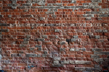 Solid red brick wall with rough old masonry. Abstract background for design