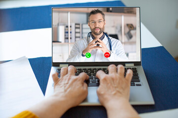Senior woman's hands behind the laptop keyboard. Online consultation with your doctor.