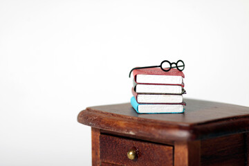 a pile of books and glasses on the table isolated against white background. Horizontal image