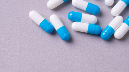 white and blue pills on a gray background. medical background