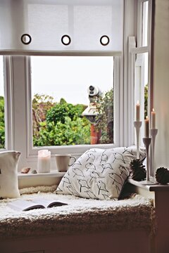 Cozy home by the sea with cup of tea,  blanket and book. Hygge home interior
