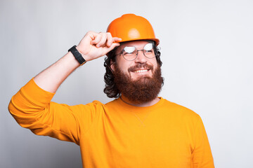 Portrait of cheerful young architect and wearing orange helmet.