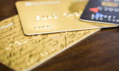 Close-up inscription gold on credit card located on a table next to other cards - 390101768