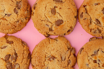 Chocolate chip cookies on pink background top view