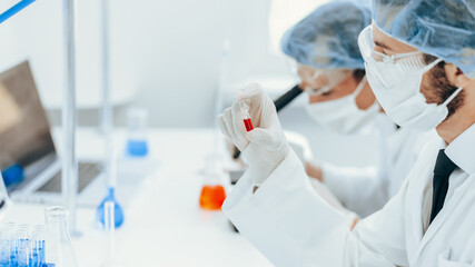 close up. virologist holds an ampoule with a new vaccine.