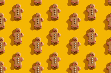 Yellow seamless background. Cute pattern. Brown gingerbread man biscuit decorative poster for kids. Fun minimalist arrangement isolated on bright orange.