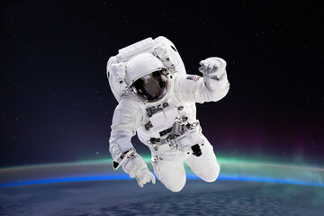 Composite image of astronaut floating in space, earth planet in the background -  Elements of this image are furnished by NASA