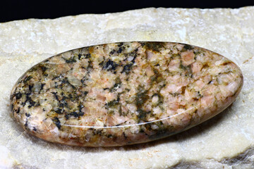 Cabochon-cut granite on white marble background
