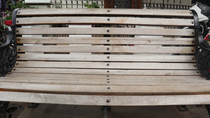 Selective and partial part image a retro style of garden bench with iron legs and armchair, photographed from above at close range