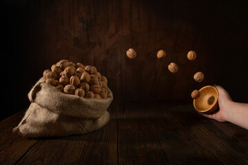 The photo shows walnuts in a bag and flying into a bag