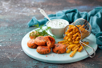 Salmon fish cutlets with fried kohlrabi and sauce of coconut yoghurt or mayonnaise, selective focus