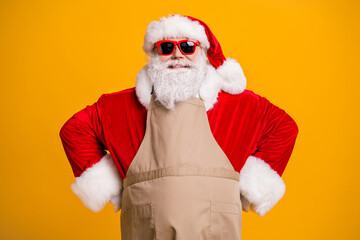 Photo of santa claus role grandpa grey beard wait children parents family take order waiter own business cafe wear red costume coat gloves sun specs cap apron isolated yellow color background