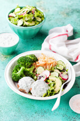 Cutlets with white sauce, broccoli, fried celery root and fresh vegetable salad, selective focus