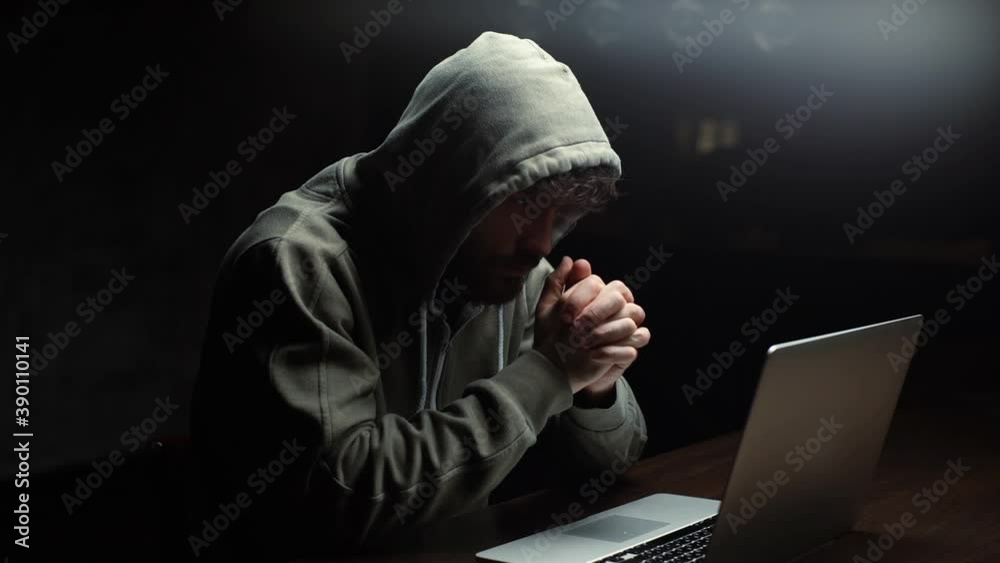 Wall mural thoughtful caucasian hacker man looking at laptop screen and working on computer thinking solving pr