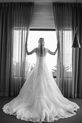 unique view of bride opening curtains and looking outside
