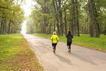 Women run at dawn in the morning park. Morning jogging in the fresh air. Cardio workout.