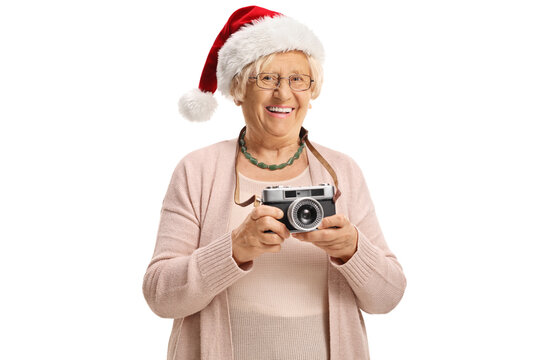 Elderly lady wearing a santa claus hat and holding a vintage camera