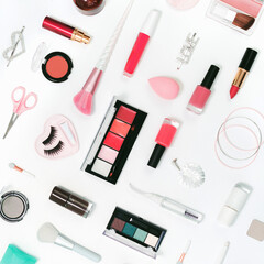 Obraz premium Feminine makeup red and pink palette accessories with nail polish manicure tools on white background. Flat lay pattern with copy space, beauty and cosmetics blogger concept