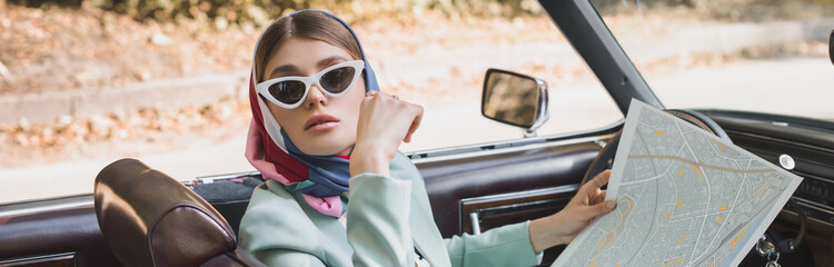 Elegant woman holding map in vintage auto, banner