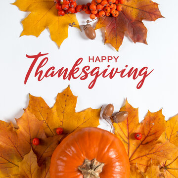 Thanksgiving greetings. Dry yellow leaves, pumpkins, berries on a white background, top view. Kaligraphic capital inscription.