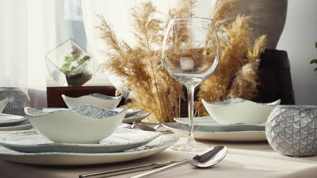 Close up of woman setting table. Housewife or waitress hands putting plates on dining table