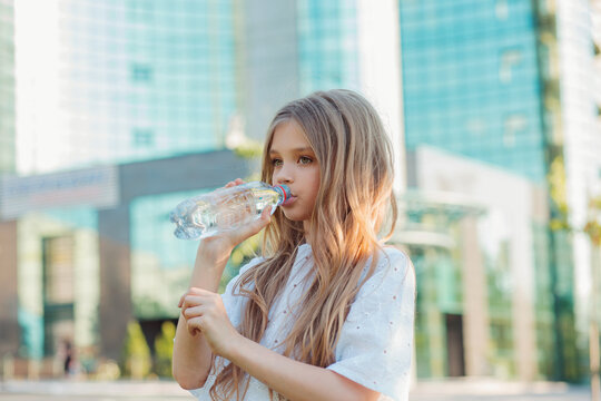 Girl Drinking Water From A Bottle In The City