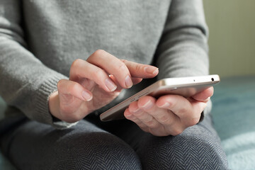 Hand of woman using smartphone on wooden table,Space for text or design